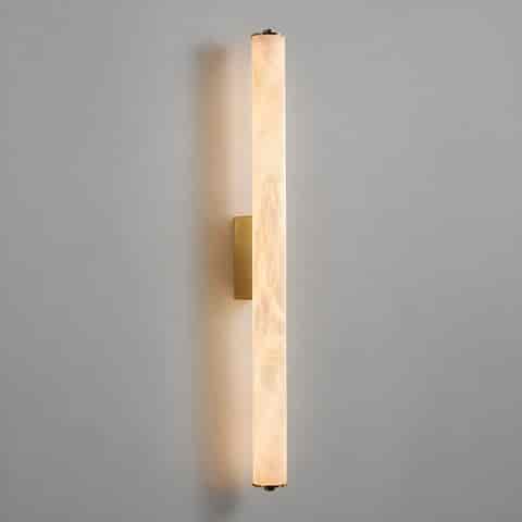 Illuminated brass vertical wall sconce with translucent marble veined cylinder diffuser